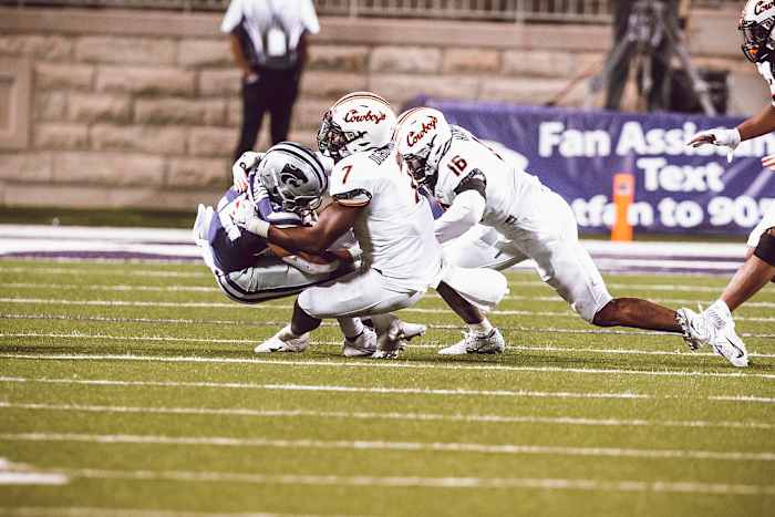 Linebacker Amen Ogbongbemiga (7) and Devin Harper (16) tackle explosive K-State running back Duece Vaughn.